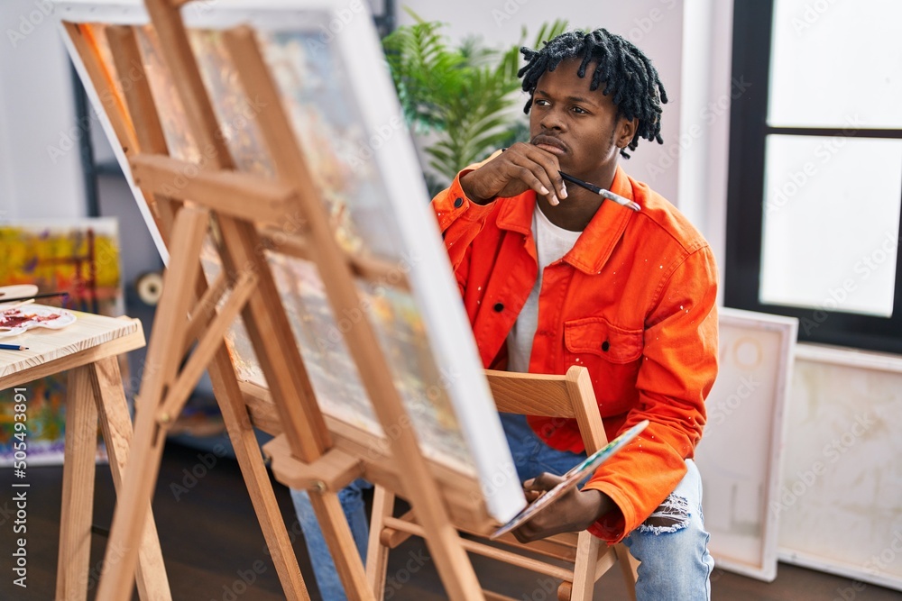 African american man artist looking draw with doubt expression at art studio