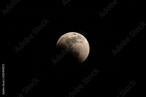 Full moon partically obscured; beginning of full lunar eclipse. Black background. 
 photo