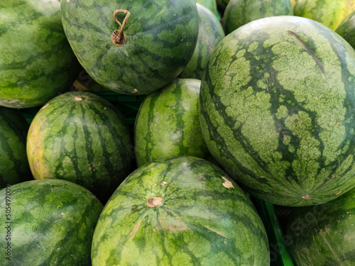 Close up of fresh watermelon fruits at stall of supermarket in Asia. Healthy and delicious dessert. Selective focus.
