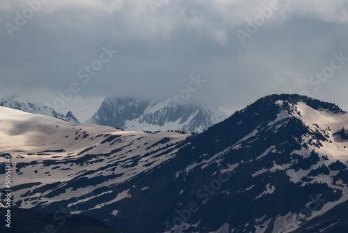 Unas cumbres del pirineo cubiertas de nubes bajas y nieve con tono marr  n por la calima