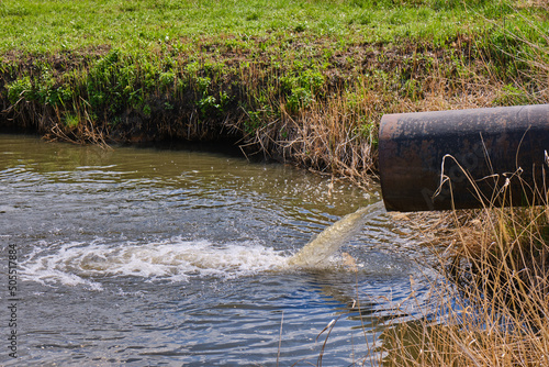 Fotografie Draining sewage from pipe into river, pollution rivers and ecology