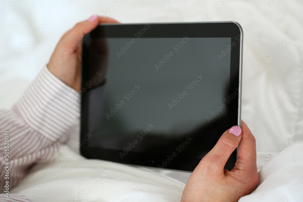 Woman holding tablet device with locked screen, turned off gadget