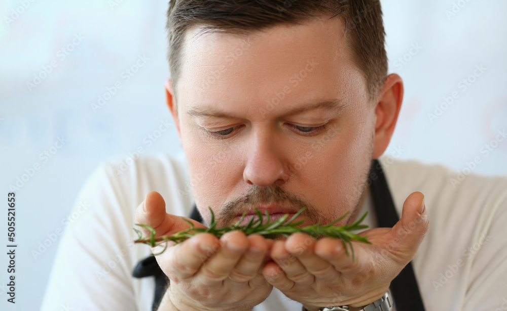 Professional chef smell twig of rosemary, herb add to dish, better taste with greenery Professional chef smell twig of rosemary, herb add to dish, better taste with greenery