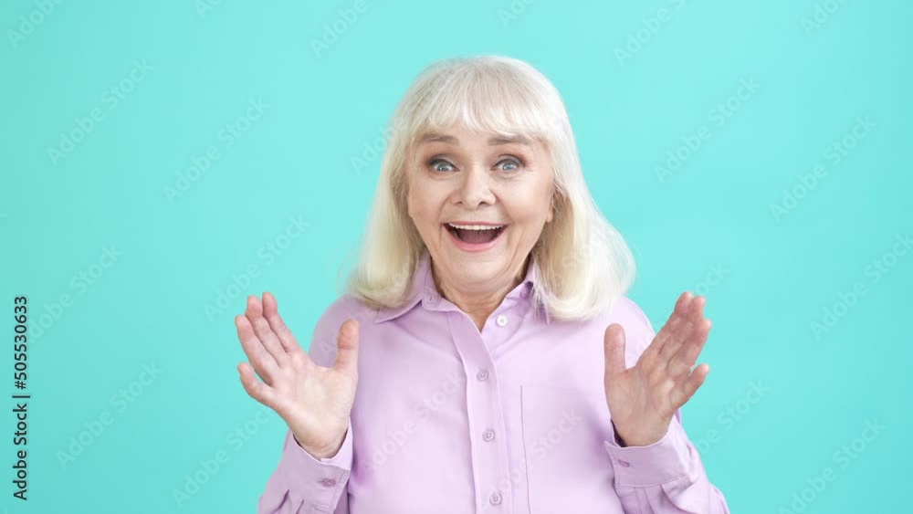 Positive aged lady impressed incredible news isolated cyan color background Positive aged lady impressed incredible news isolated cyan color background
