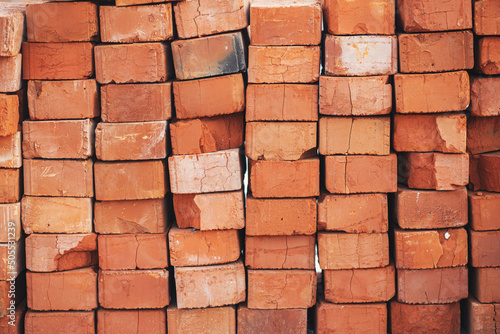 Stack of bricks masonry close up. Process of house building and building materials concept. Red bricks for laying at construction site. Brick wallpaper pattern