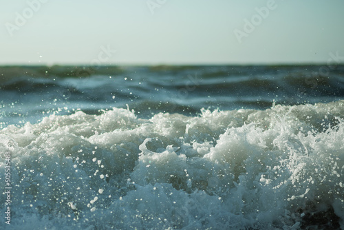 .Foam and splashing water from a wave in the foreground