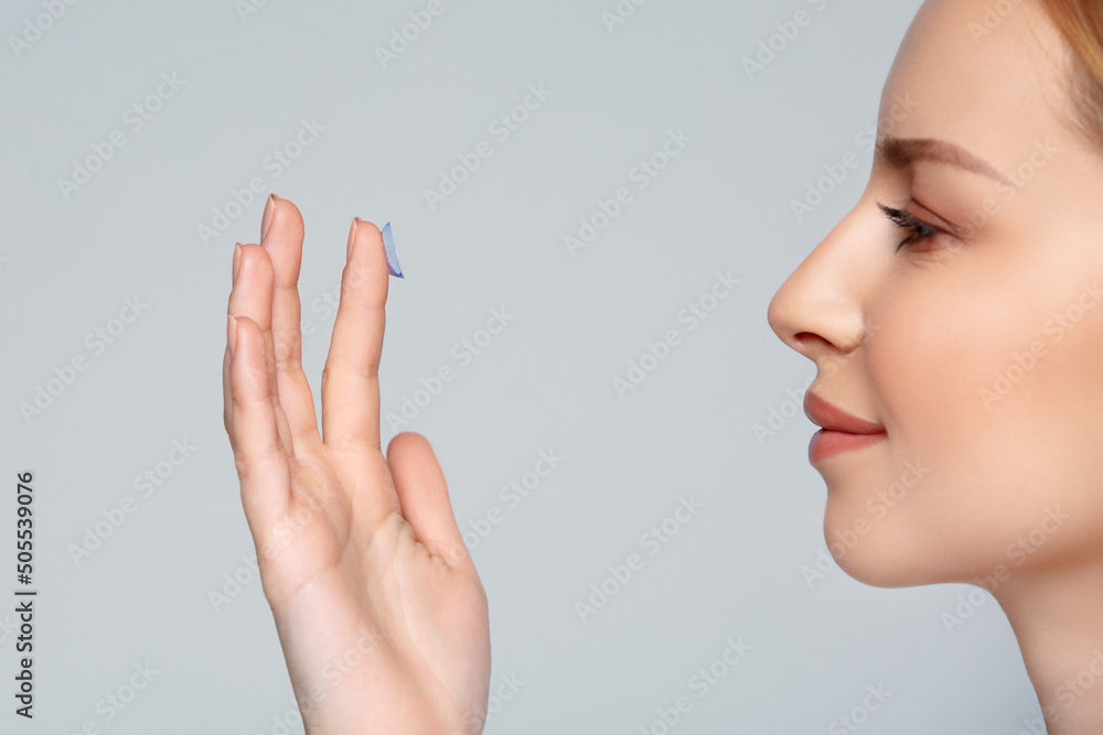 Αυτοκόλλητο Close up woman putting eye contact lense in or taking out, holding on finger