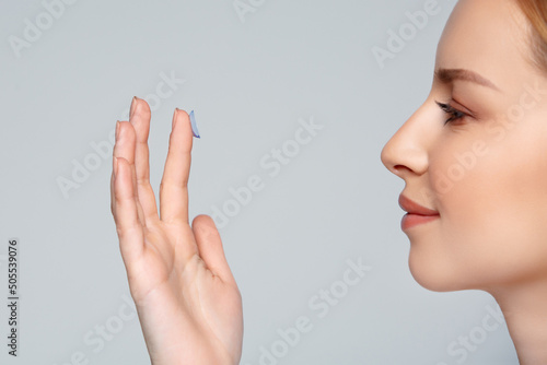 Close up woman putting eye contact lense in or taking out, holding on finger. Eye disorder treatment like myopia or nearsightedness, astigmatism or cosmetic lenses. Vision improvement and correction. photo