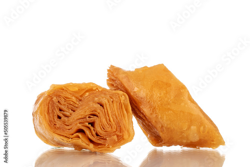 Two slices of sweet honey baklava, close-up, isolated on a white background.