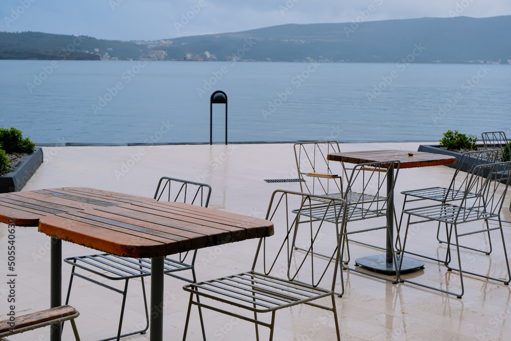 table and chairs on the beach terrace at the rainy day. minimal natural background, relax and vacation concept