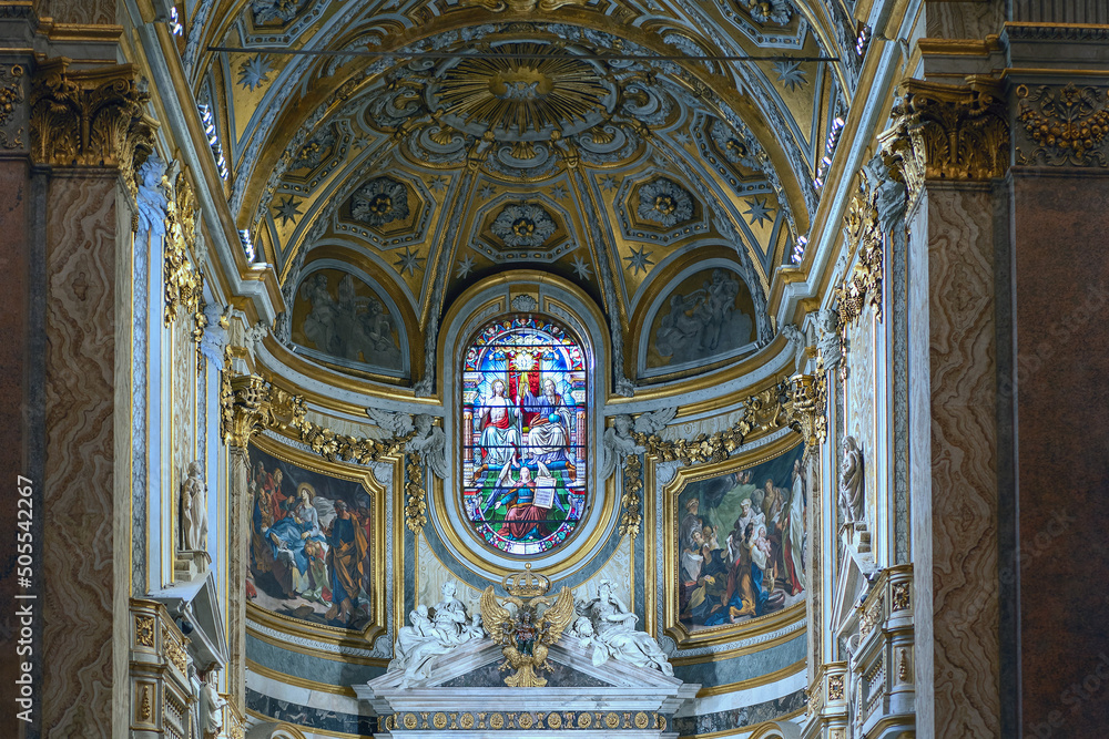 The interior of the Catholic Cathedral in Rome with paintings on religious themes and praying parishioners
