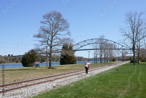 A woman working at railroad with the background of Bourne bridge and cape cod canal MA USA photo