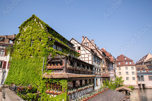 The Little France (La Petite France) in Strasbourg, Alsase, France. Old medieval buildings and ivy covered building near canal.  photo