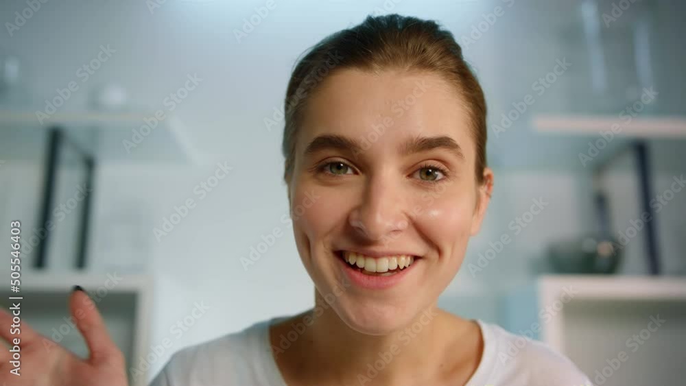Smiling girl recording blog at home closeup. Beautiful blond woman waving hand