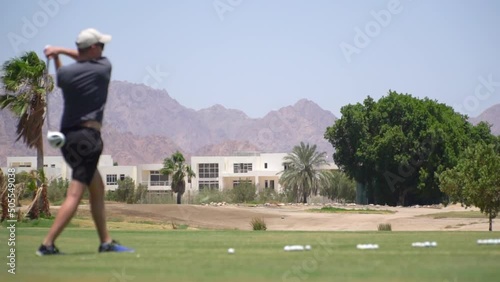 Driving Range Golf. Man practicing with golf club. Slow motion