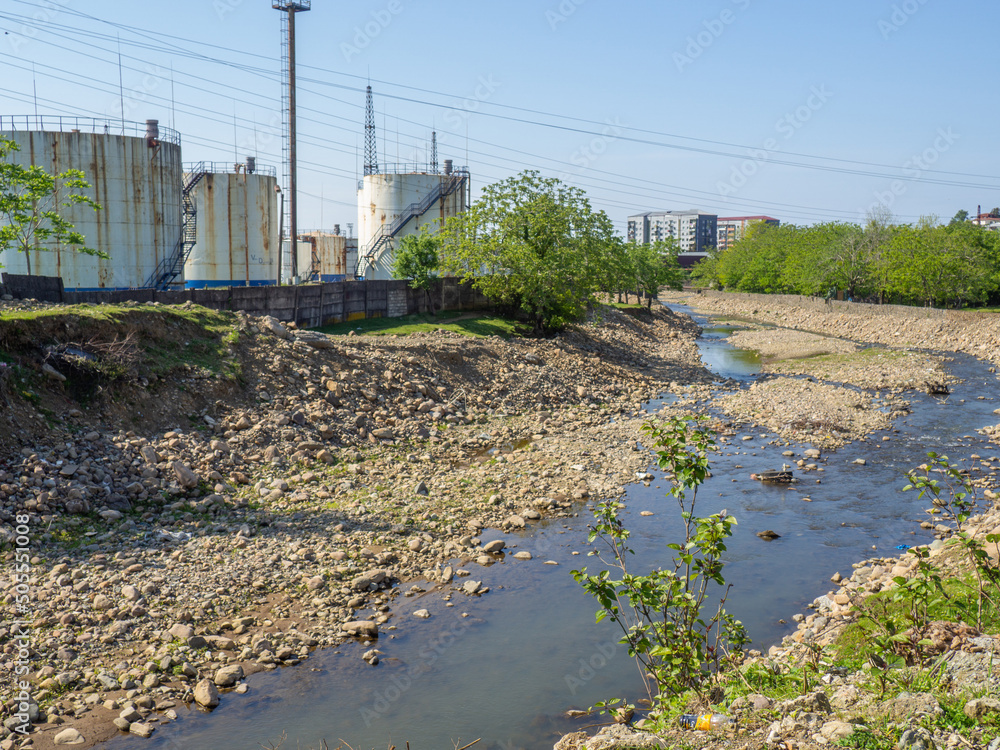 River and tanks with gasoline. Industry along the river. Human and nature. Ecology  nature pollution
