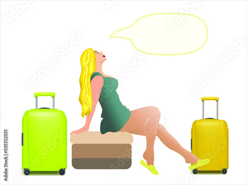 Fashion young beautiful girl in blue short dress sitting on a couch. Beautiful sensual blonde woman  in a green short dress dreaming about vacation. Near the girl are two travel bags 