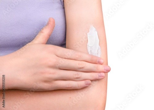 A girl applying sunscreen isolated on white background. Woman moisturizing her arm with cosmetic cream. Skincare concept.