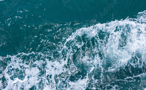Beautiful sea waves with foam of blue and turquoise color. Abstract blue sea water with white wave. Blue and white waves of the ship road on the water sea ocean.