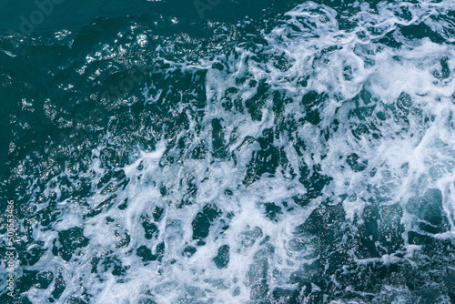 Beautiful sea waves with foam of blue and turquoise color. Abstract blue sea water with white wave. Blue and white waves of the ship road on the water sea ocean.