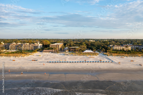 View of Coligny beach on Hilton Head Island.Ocean view at sunset with trees and hotels in foreground photo
