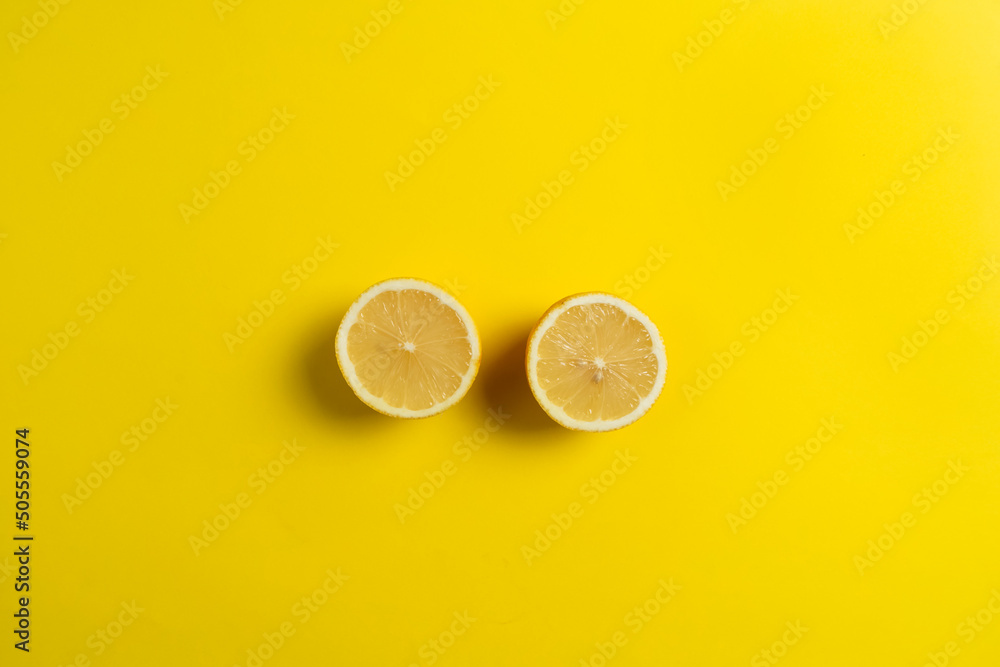 Top view of two lemons cut in half , isolated on yellow background. Healthy food concept.