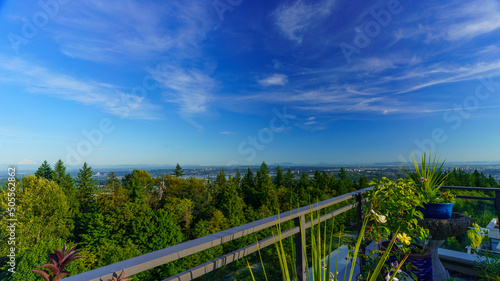 Panoramic summer view of BC Lower Mainland with Straits of Georgia and Gulf Islands on far horizon as seen from a Burnaby Mountain rooftop patio garden.