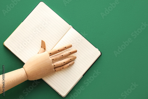 Wooden hand with notebook o...