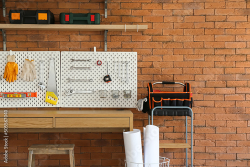 Desk and pegboard with tools in carpentry workshop photo