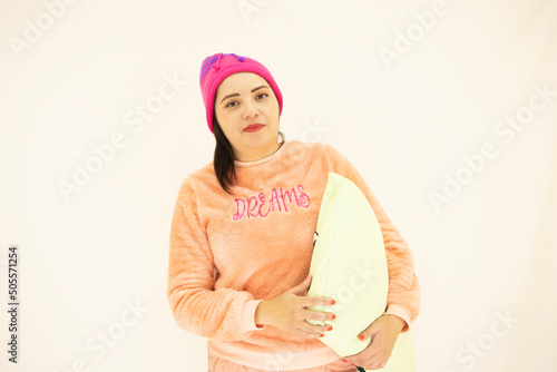 cute young white asian woman wearing pink pajamas and a night cap, ready to sleep while holding a pillow, on white background
