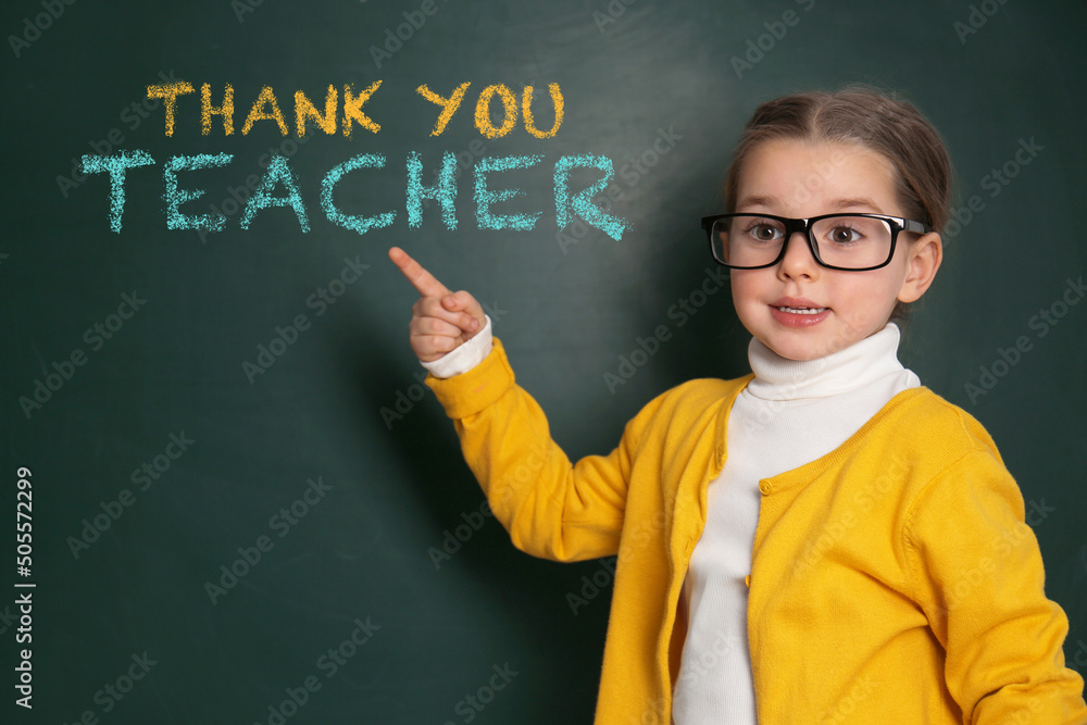 Cute little girl near chalkboard with phrase Thank You Teacher