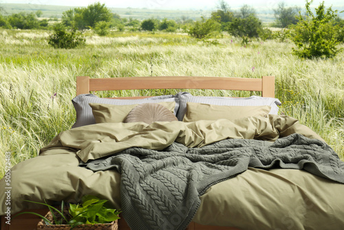 Fototapeta Naklejka Na Ścianę i Meble -  Comfortable bed with soft pillows in meadow on sunny day
