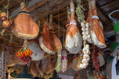 Photography Low-angle shot of hams hanging from the ceiling in a deli, Rome, Italy