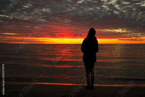 A Young Adolescent Girl Looks up in Awe, Wonder, and Admiration at a Magnificent Sunset Sky