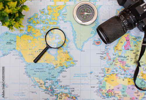 Planning a vacation trip with the help of a world map with other travel accessories.