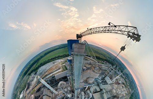 Tableau sur toile Aerial view from high altitude of little planet earth with cement factory tower with high concrete plant structure at industrial production area at sunset