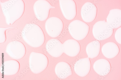 Texture of moisturizer cream on pink background close-up.
