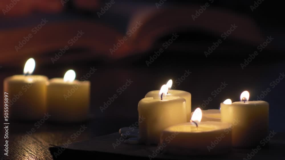 pages of a book flip by man's hand while lit by candles 4K pages of a book flip by man's hand while lit by candles 4K