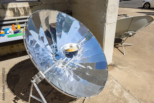 Cooking with sun energy, parabolic solar oven in the middle of cooking a dish thanks to solar energy photo