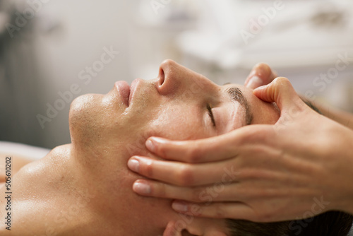 a man is given a therapeutic massage of the body and face in a spa salon