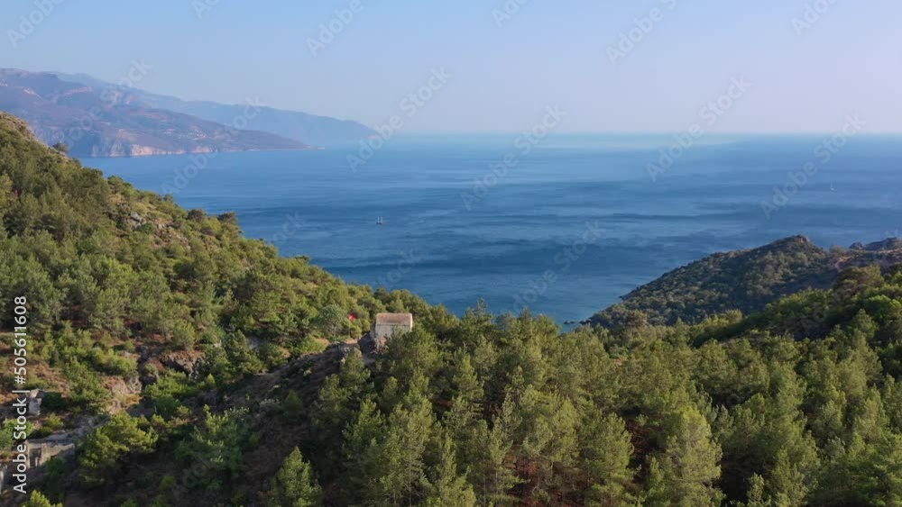 wide aerial view of whats left of the abandoned Kayakoy village with one last building on top of a hill overlooking the blue Mediterranean Sea on a summer day in Fethiye Turkey wide aerial view of whats left of the abandoned Kayakoy village with one last building on top of a hill overlooking the blue Mediterranean Sea on a summer day in Fethiye Turkey