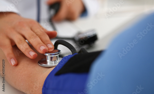 Nurse measure blood pressure with tonometer tool in clinic