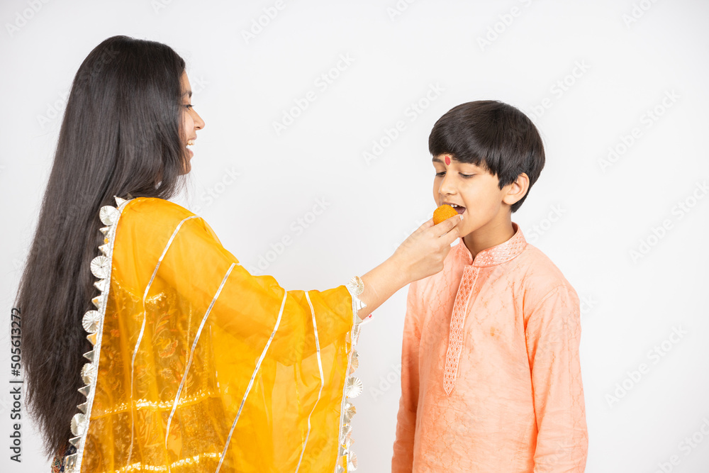 Φωτογραφία Young Indian brother and sister celebrating Diwali, rakshabandhan or bhai dooj festival isolated on white studio background