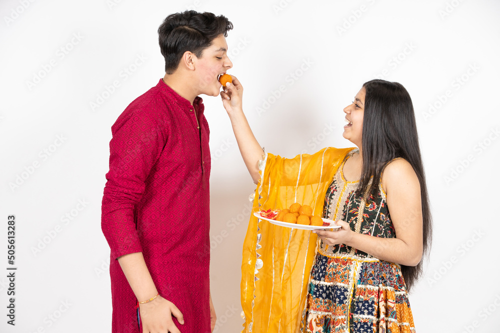 Φωτογραφία Young Indian brother and sister celebrating Diwali, rakshabandhan or bhai dooj festival isolated on white studio background