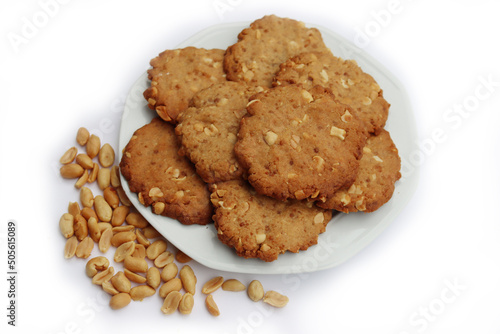 Peanut butter cookies on a plate with peanuts and peanut butter cream on white background. Traditional american dessert 