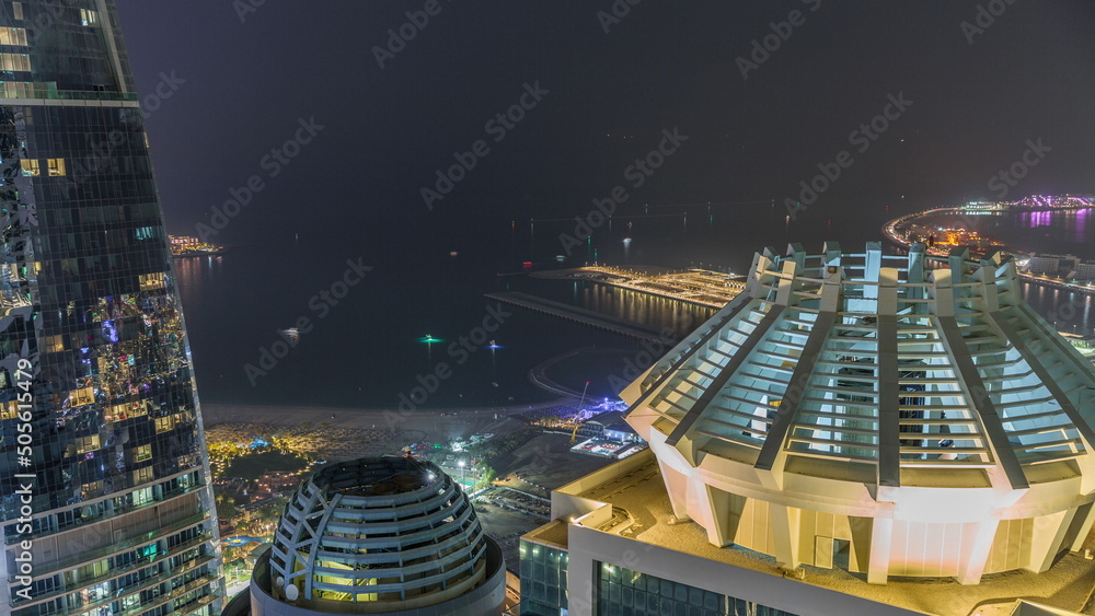 Obraz premium Aerial view of JBR and Dubai Marina skyscrapers and luxury buildings night timelapse from above