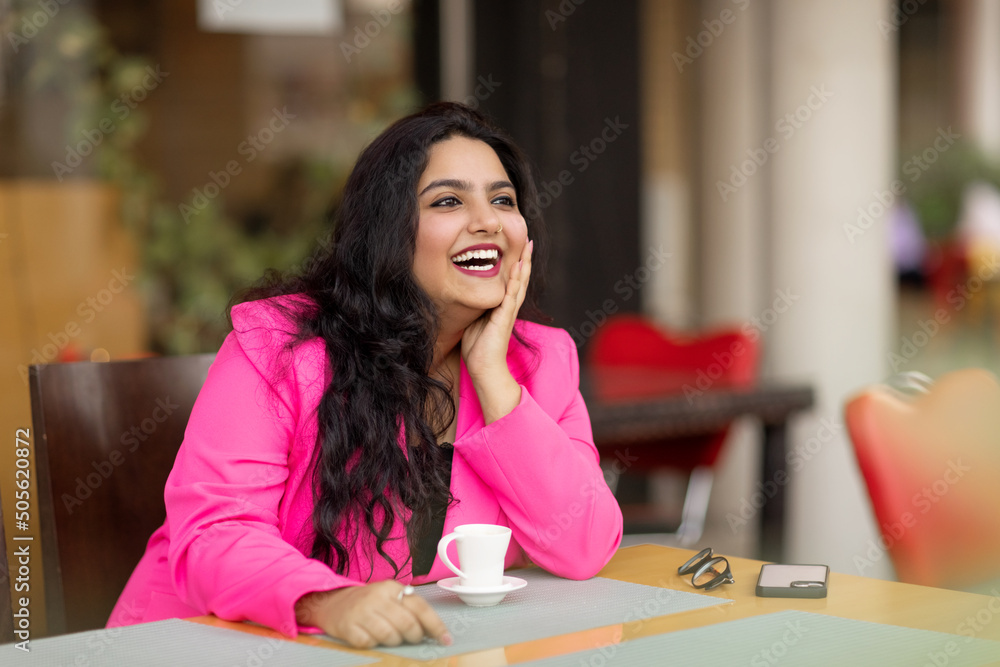Φωτογραφία Portrait of a young and stylish Indian woman sitting in a cafe and enjoying a dr