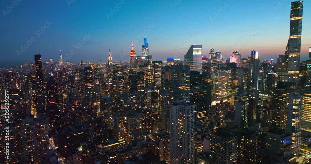 Amazing New York city full of lights in the evening. Beautiful shining skyscrapers at the backdrop of blue evening sky. Amazing New York city full of lights in the evening. Beautiful shining skyscrapers at the backdrop of blue evening sky.