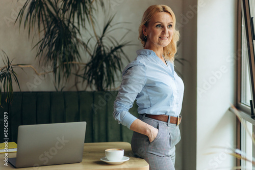 Portrait of a happy mature woman in stylish clothes. successful women in a cafe-pub.