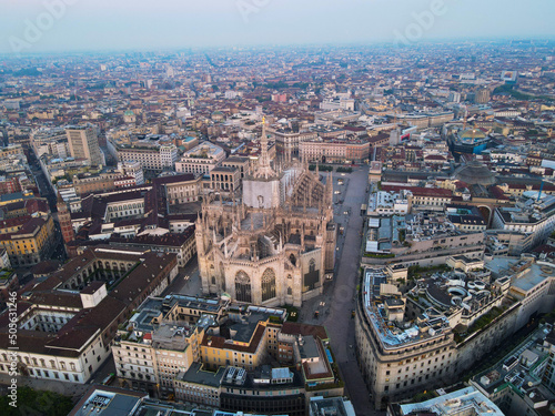 Aerial view of Duomo di Milano Cathedral in Duomo Square. Gothic cathedral in the center of Milan. Drone view of the gallery and Milano rooftops, in north Italy, Lombardia. Birds eye of Duomo facade.